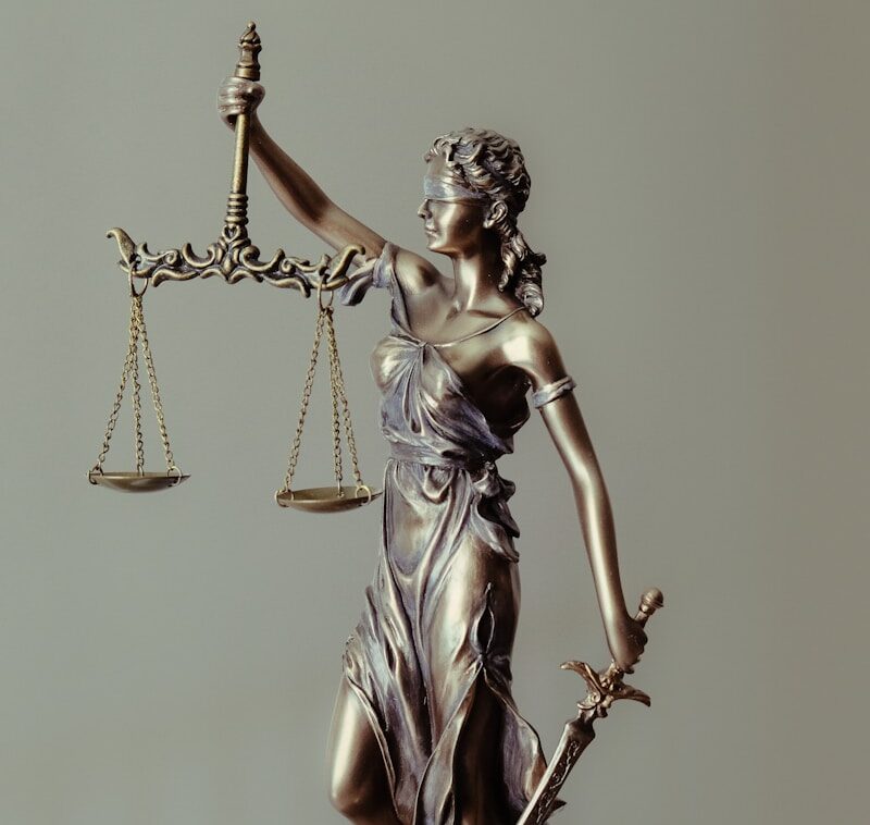 woman in gold dress holding sword figurine